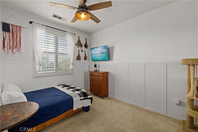 5058 Meadowsweet Dr, Palmdale, CA 93551 - bedroom with a decorative wall, light carpet, ceiling fan, and wainscoting