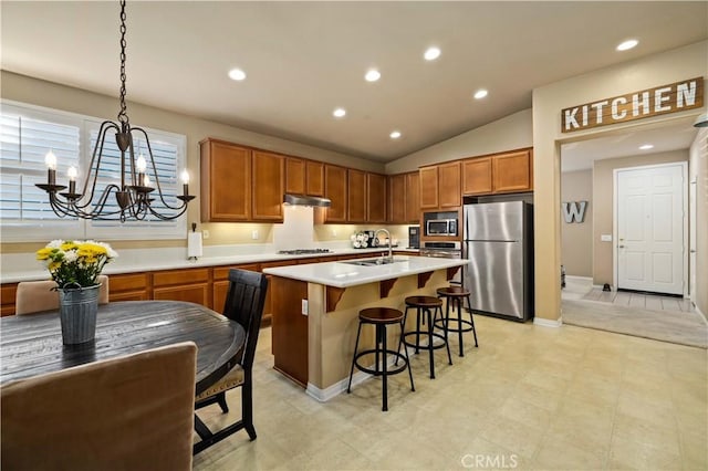 5058 Meadowsweet Dr, Palmdale, CA 93551 - kitchen featuring appliances with stainless steel finishes, vaulted ceiling, light countertops, a chandelier, and a breakfast bar area
