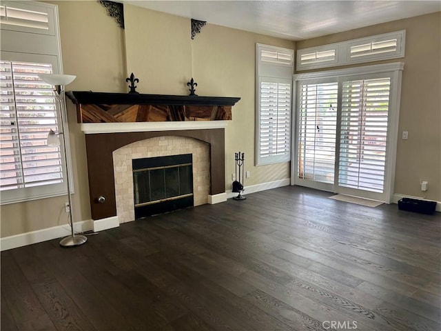 7440 Apple Blossom Ct, Highland, CA 92346 - unfurnished living room featuring baseboards, hardwood / wood-style floors, plenty of natural light, and a glass covered fireplace
