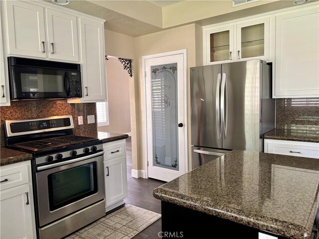 7440 Apple Blossom Ct, Highland, CA 92346 - kitchen with appliances with stainless steel finishes, white cabinets, glass insert cabinets, dark stone counters, and decorative backsplash