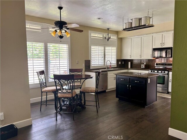 7440 Apple Blossom Ct, Highland, CA 92346 - kitchen with appliances with stainless steel finishes, dark countertops, a sink, a ceiling fan, and white cabinetry