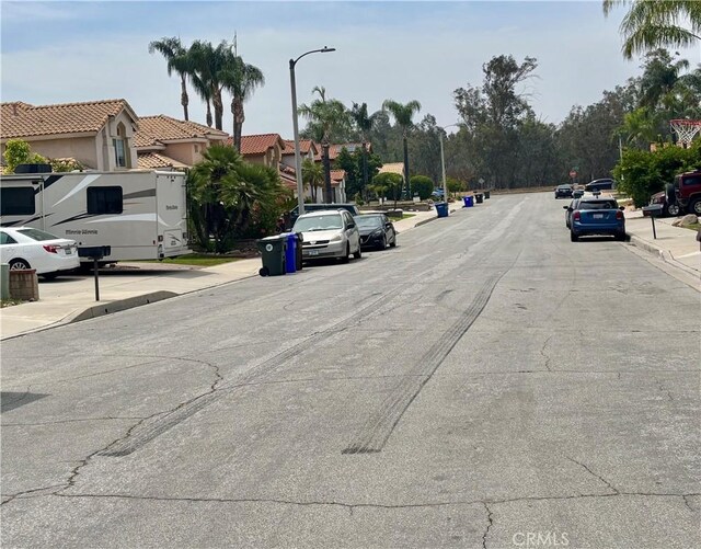 7440 Apple Blossom Ct, Highland, CA 92346 - view of asphalt street featuring sidewalks, street lights, and curbs