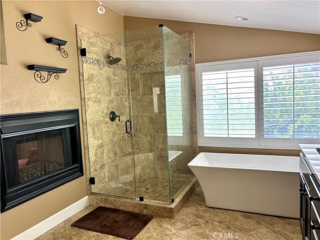 7440 Apple Blossom Ct, Highland, CA 92346 - bathroom featuring vaulted ceiling, a freestanding bath, a shower stall, vanity, and a fireplace