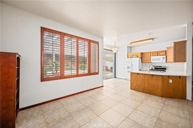 15863 Falcon Ct, Fontana, CA 92337 - kitchen featuring white appliances, a peninsula, light countertops, light tile patterned flooring, and baseboards