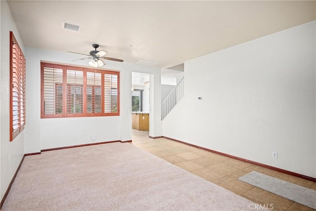 15863 Falcon Ct, Fontana, CA 92337 - carpeted empty room featuring ceiling fan, baseboards, tile patterned floors, and stairs
