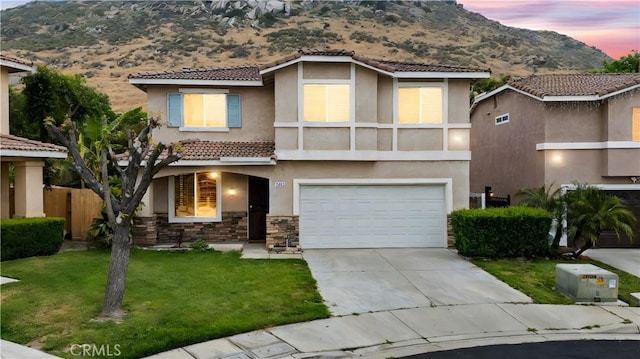 15863 Falcon Ct, Fontana, CA 92337 - view of front of home featuring a mountain view, an attached garage, stucco siding, and a tile roof