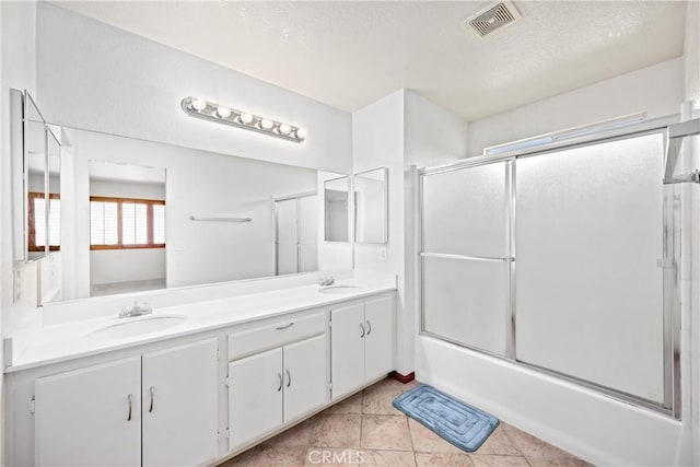 15863 Falcon Ct, Fontana, CA 92337 - bathroom with double vanity, combined bath / shower with glass door, and a textured ceiling