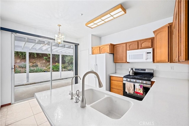 15863 Falcon Ct, Fontana, CA 92337 - kitchen with white appliances, a sink, a chandelier, light countertops, and pendant lighting
