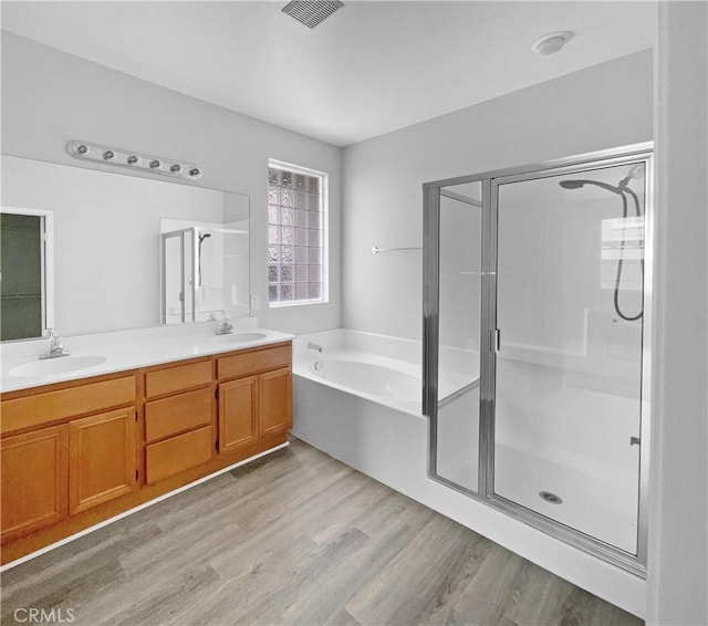 1281 Smoke Tree Ln, Beaumont, CA 92223 - full bathroom featuring a garden tub, a stall shower, wood finished floors, and double vanity