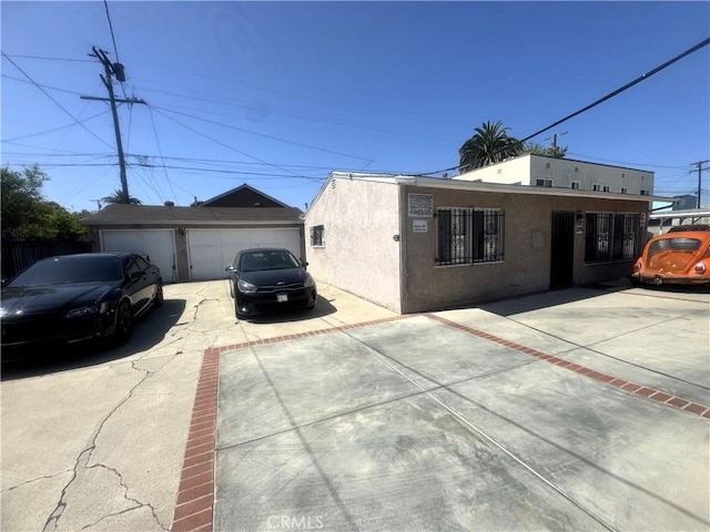 1022 W 103rd St, Los Angeles, CA 90044 - view of front of house with stucco siding, an outbuilding, and a garage