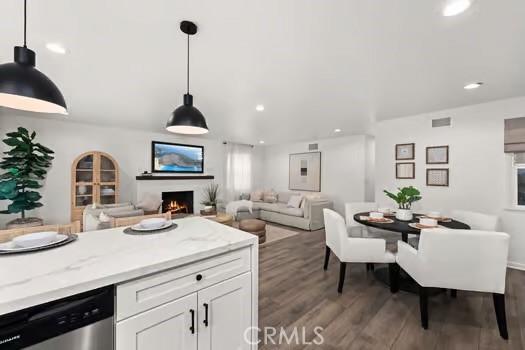10946 Kentucky Ave, Whittier, CA 90603 - kitchen featuring stainless steel dishwasher, dark wood-style flooring, recessed lighting, a lit fireplace, and white cabinetry