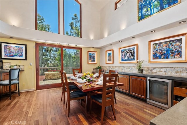 7626 E Saddlehill Trl, Orange, CA 92869 - dining room featuring wine cooler, a high ceiling, light wood finished floors, and baseboards