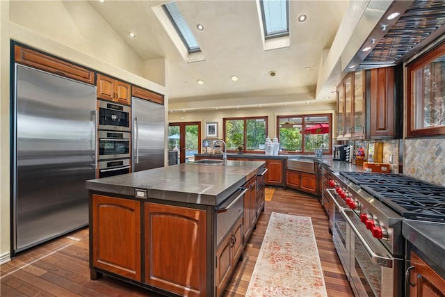 7626 E Saddlehill Trl, Orange, CA 92869 - kitchen with premium appliances, a skylight, an island with sink, dark wood-style flooring, and recessed lighting
