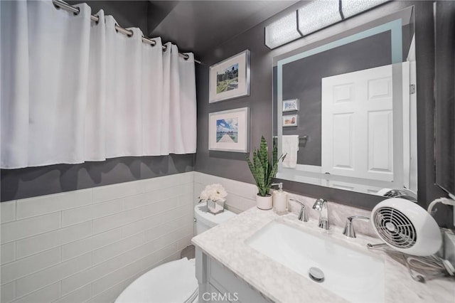 1140 Pacific Ave Unit 10, Long Beach, CA 90813 - bathroom with toilet, vanity, tile walls, and wainscoting