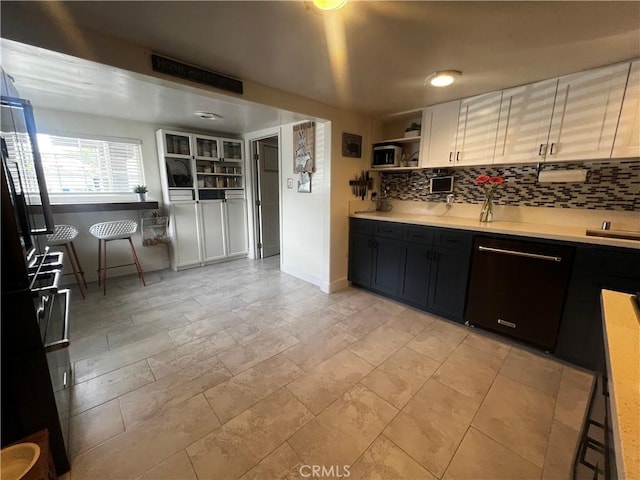 1767 W Chandeleur Dr, San Pedro, CA 90732 - kitchen featuring black dishwasher, light countertops, decorative backsplash, open shelves, and baseboards