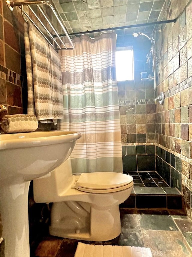 1767 W Chandeleur Dr, San Pedro, CA 90732 - bathroom featuring a shower stall, tile walls, and stone finish floors