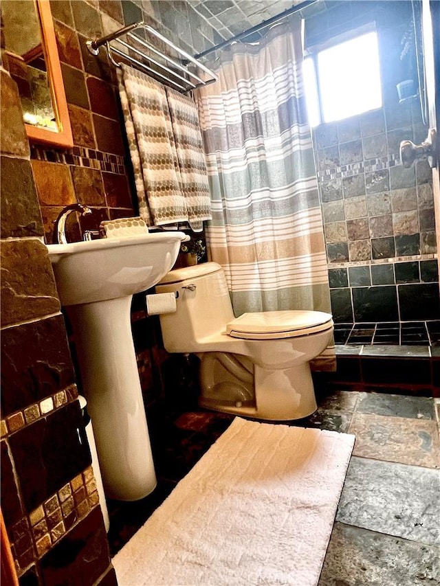 1767 W Chandeleur Dr, San Pedro, CA 90732 - full bath featuring a tile shower, stone tile flooring, and tile walls