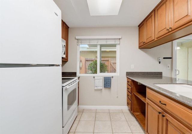 7879 Rancho Fanita Unit A, Santee, CA 92071 - kitchen featuring white appliances, brown cabinetry, light tile patterned flooring, and baseboards