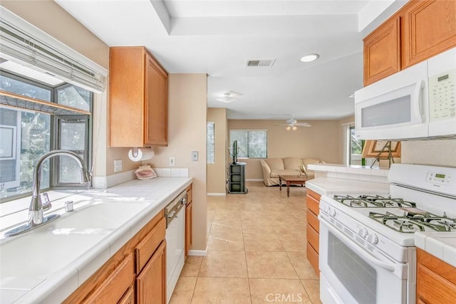 56 Coventry Ln Unit 293, Aliso Viejo, CA 92656 - kitchen with white appliances, tile countertops, ceiling fan, light tile patterned floors, and open floor plan