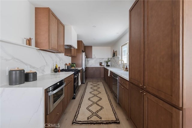 1709 Wollacott St, Redondo Beach, CA 90278 - kitchen with appliances with stainless steel finishes, decorative backsplash, a sink, light stone counters, and light wood-style floors