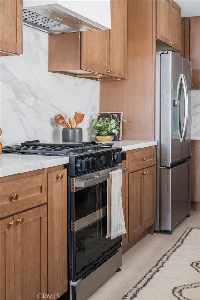 1709 Wollacott St, Redondo Beach, CA 90278 - kitchen featuring range with gas cooktop, stainless steel fridge, range hood, tasteful backsplash, and brown cabinetry