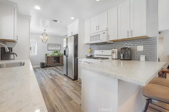 11025 Shaw St, Rancho Cucamonga, CA 91701 - kitchen featuring white appliances, white cabinets, backsplash, light wood-type flooring, and recessed lighting
