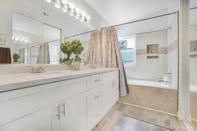 11025 Shaw St, Rancho Cucamonga, CA 91701 - bathroom featuring double vanity, wood finished floors, and tiled shower / bath combo