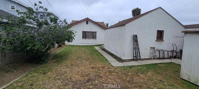 7819 Dalton Ave, Los Angeles, CA 90047 - rear view of property featuring stucco siding and a lawn