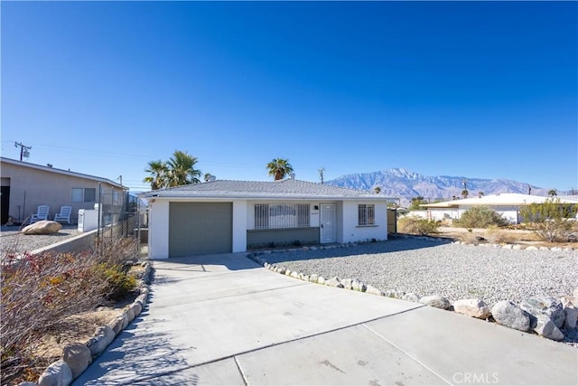 66691 Flora Ave, Desert Hot Springs, CA 92240 - ranch-style house with concrete driveway, a mountain view, stucco siding, and a garage