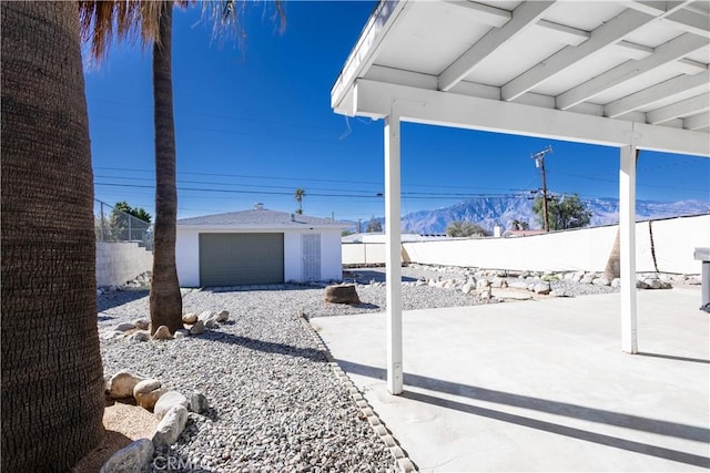 66691 Flora Ave, Desert Hot Springs, CA 92240 - fenced backyard featuring an outdoor structure, a patio area, and a mountain view