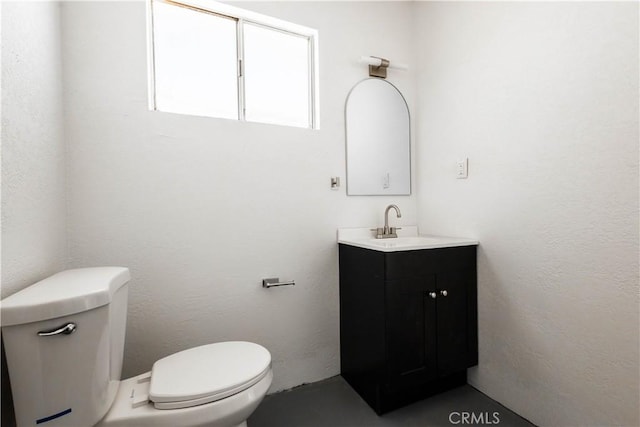 66691 Flora Ave, Desert Hot Springs, CA 92240 - half bathroom with toilet, vanity, and a textured wall