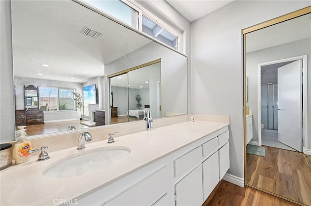 9256 Crocus Ave, Fountain Valley, CA 92708 - bathroom featuring double vanity, wood finished floors, and a shower with shower door