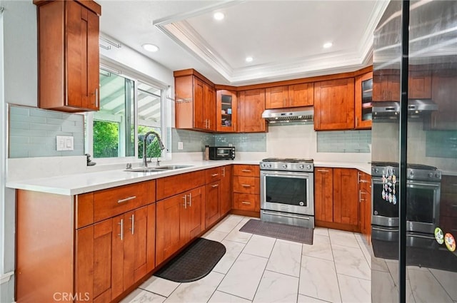 9256 Crocus Ave, Fountain Valley, CA 92708 - kitchen featuring stainless steel gas range, under cabinet range hood, brown cabinetry, light countertops, and ornamental molding