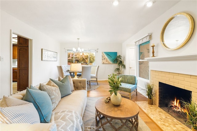 1357 Curtis Ave, Manhattan Beach, CA 90266 - living area with a brick fireplace, wood finished floors, a chandelier, and baseboards