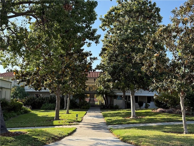 680 Via Alhambra Unit O, Laguna Woods, CA 92637 - view of property hidden behind natural elements with a tiled roof and a front lawn