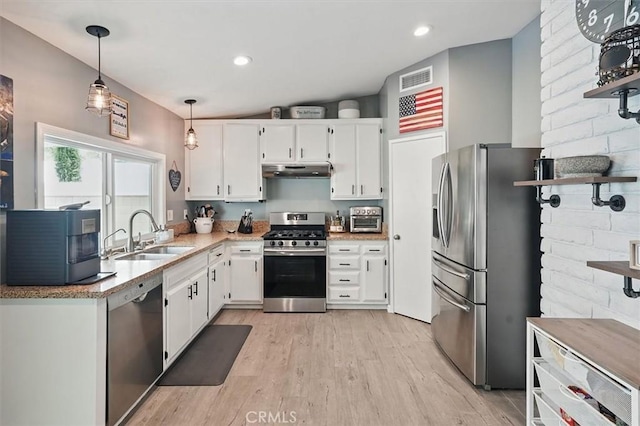 23021 Posada Dr, Valencia, CA 91354 - kitchen featuring appliances with stainless steel finishes, a sink, under cabinet range hood, light wood-type flooring, and white cabinetry