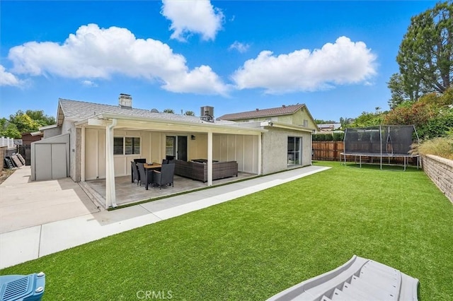 23021 Posada Dr, Valencia, CA 91354 - back of house featuring a trampoline, a patio area, outdoor lounge area, a chimney, and a storage shed