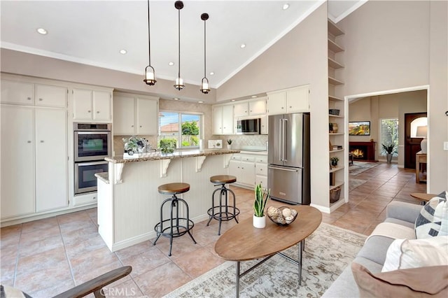 3531 Almond St, Irvine, CA 92606 - kitchen featuring stainless steel appliances, a breakfast bar area, tasteful backsplash, recessed lighting, and white cabinets