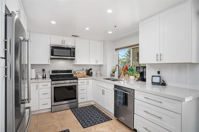 2922 Estancia, San Clemente, CA 92673 - kitchen with stainless steel appliances, a sink, decorative backsplash, white cabinetry, and light tile patterned floors