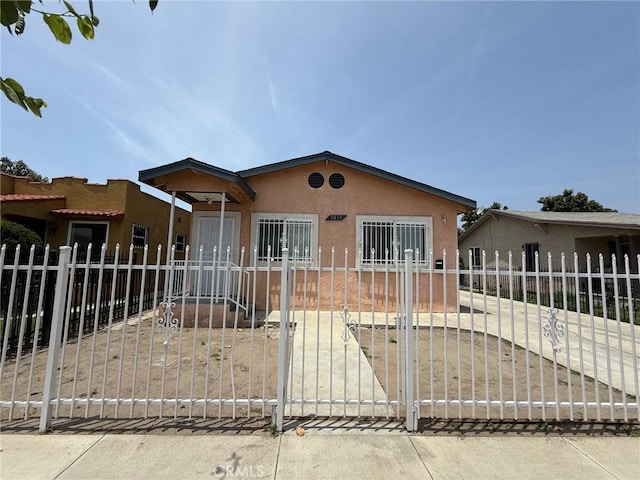 9815 Holmes Ave Unit 2, Los Angeles, CA 90002 - view of front of home featuring stucco siding, a fenced front yard, and a gate