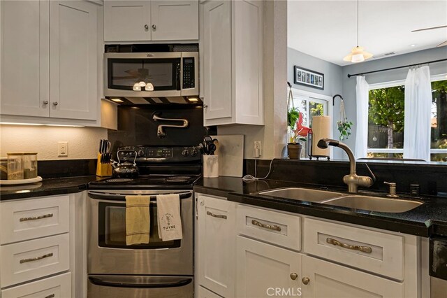 13 Avante Way, Chico, CA 95973 - kitchen with stainless steel appliances, a sink, dark countertops, and white cabinetry