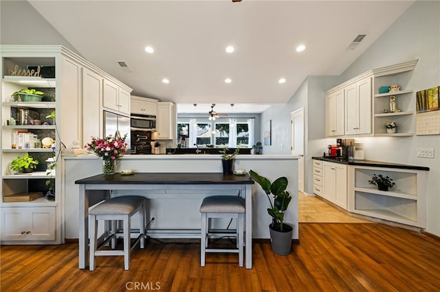 13 Avante Way, Chico, CA 95973 - kitchen featuring open shelves, stainless steel microwave, a peninsula, wood finished floors, and a kitchen breakfast bar