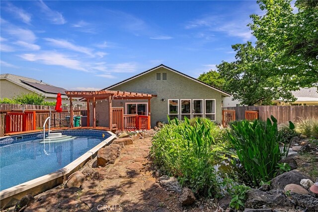 13 Avante Way, Chico, CA 95973 - back of house with a pergola, a fenced backyard, an outdoor pool, stucco siding, and a deck
