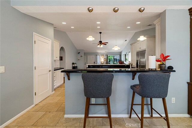 13 Avante Way, Chico, CA 95973 - kitchen featuring stainless steel fridge, vaulted ceiling, a peninsula, dark countertops, and a breakfast bar area