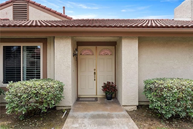 18301 Gum Tree Ln, Huntington Beach, CA 92646 - view of exterior entry with stucco siding and a tile roof