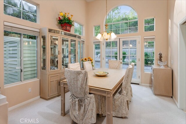 17910 Montague Ct, Granada Hills, CA 91344 - dining area with light colored carpet, a towering ceiling, a chandelier, and healthy amount of natural light