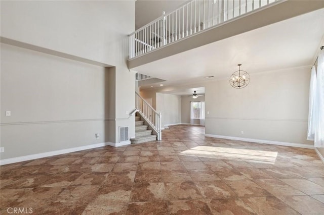 7538 N Erie Ave, Fresno, CA 93722 - unfurnished living room with stairway, stone finish flooring, a chandelier, a high ceiling, and baseboards