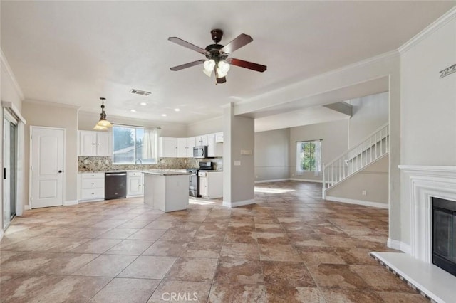 7538 N Erie Ave, Fresno, CA 93722 - kitchen with stainless steel appliances, open floor plan, crown molding, plenty of natural light, and backsplash