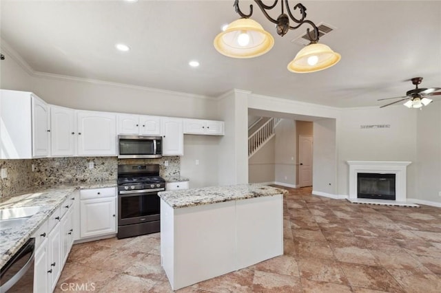 7538 N Erie Ave, Fresno, CA 93722 - kitchen with appliances with stainless steel finishes, ornamental molding, tasteful backsplash, light stone countertops, and ceiling fan