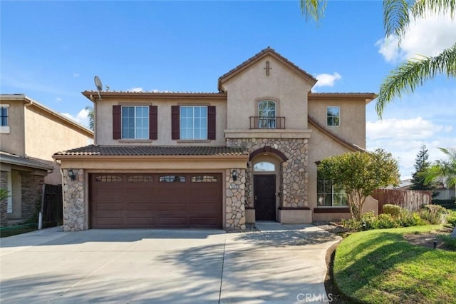 7538 N Erie Ave, Fresno, CA 93722 - mediterranean / spanish-style house with a garage, concrete driveway, stucco siding, stone siding, and a balcony